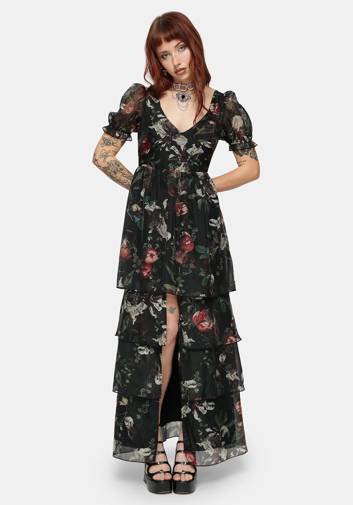 Woman wearing a black fruit printed dress on a white studio background