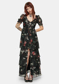 Woman wearing a black fruit printed dress on a white studio background