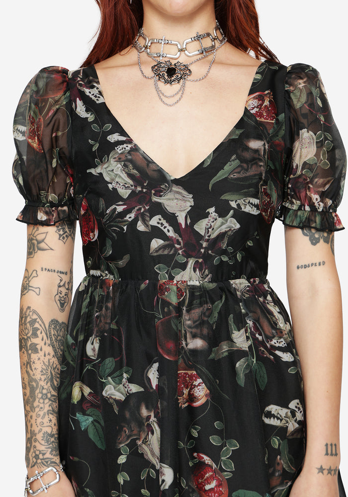 Black floral and fruit patterned maxi dress worn by a model