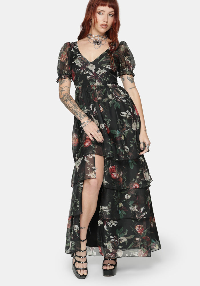 Woman wearing a fruit printed maxi dress with a white background