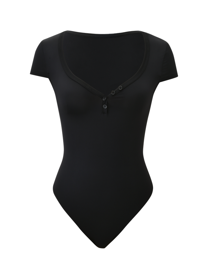 The TIGERMIST JAXX BODYSUIT - BLACK is a black short sleeve thong-back bodysuit with a scooped neckline and three front buttons, shown against a plain white background.