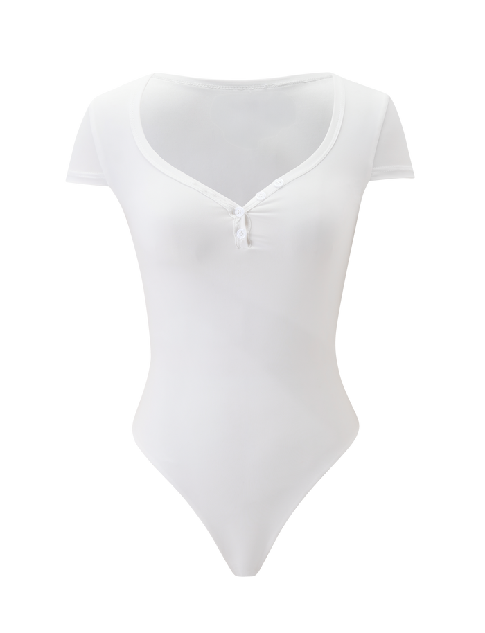The JAXX BODYSUIT - WHITE by TIGERMIST features a deep scoop neckline, front buttons, small neck bow, short sleeves, and a thong-back design, shown on a plain white background.