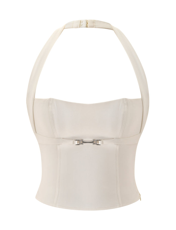 Introducing the KITTIE BUCKLE TOP - CREAM by TIGERMIST: This cream-colored, structured halter neck top features a sweetheart neckline and fitted bodice, accented with a decorative buckle detail at the front. Crafted from a smooth, subtly lustrous fabric, this chic corset-inspired piece is perfect for occasions ranging from dinner dates to bridal showers.