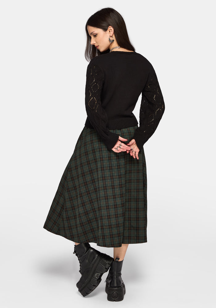Woman wearing a black sweater and plaid skirt on a white background