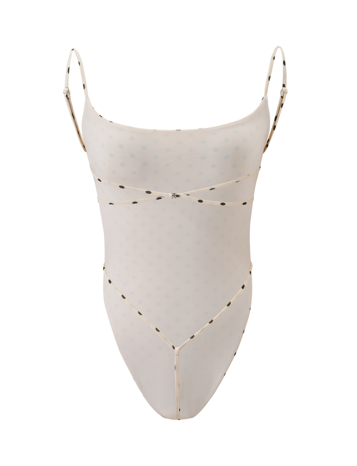 The MINERVA BODYSUIT - CREAM DOT by TIGERMIST features a sheer, light beige design with thin adjustable straps, a subtle dotted pattern, bodycon silhouette, high-cut leg, and minimalistic style.