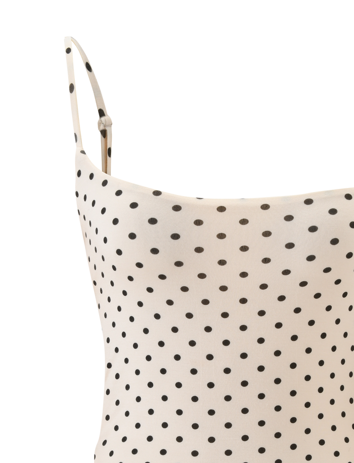 Close-up of the TIGERMIST MINERVA BODYSUIT - CREAM DOT, featuring thin adjustable straps and a black polka dot pattern, highlighting its chic bodycon silhouette against a white background.