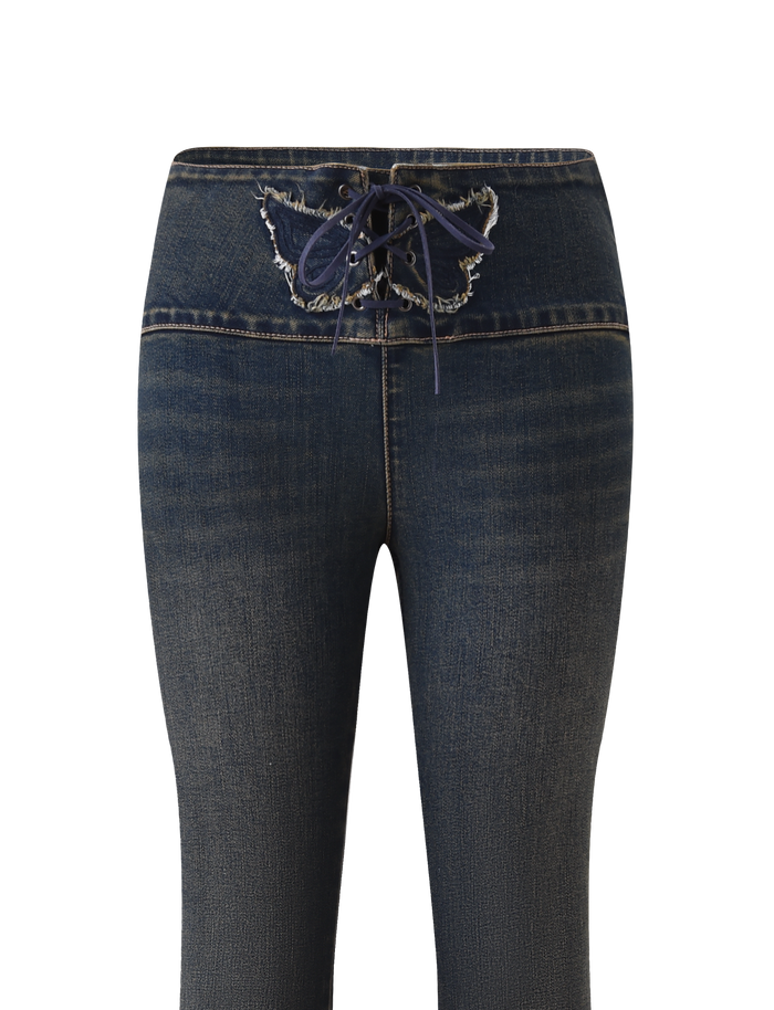 The RIONA JEAN - MIDWASH by TIGERMIST features dark blue denim, a front lace-up closure, frayed waistband edges, subtle thigh fading, and a flattering flared leg. Shown against a plain white background.