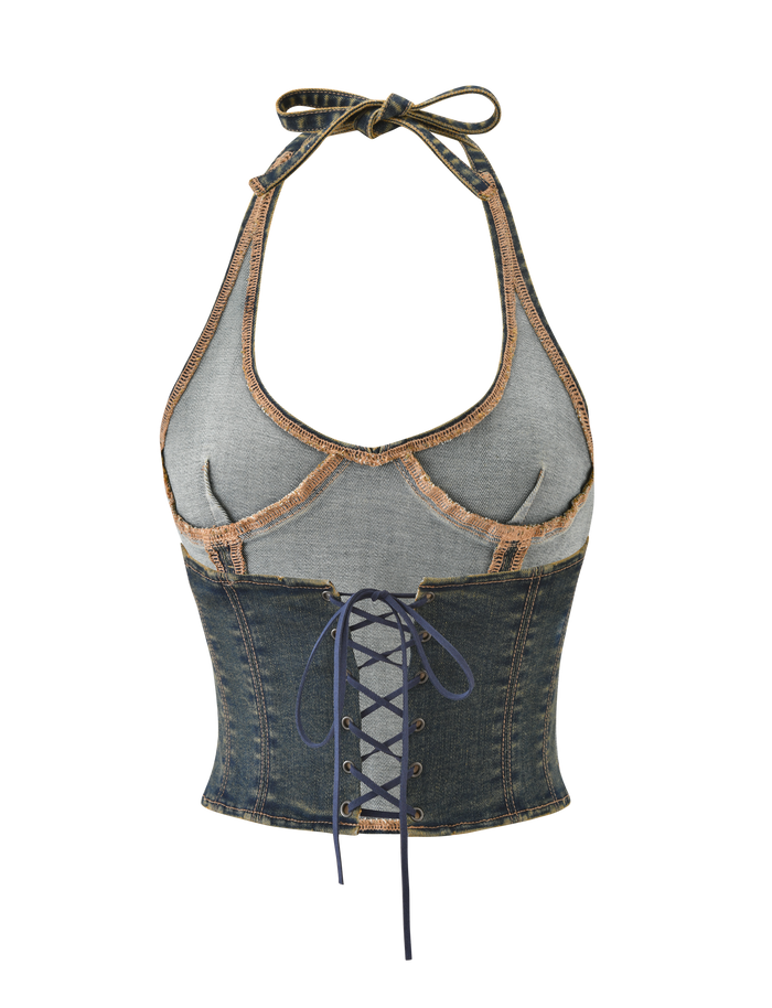 The RIONA TOP - MIDWASH by TIGERMIST is a denim halter top featuring exposed seams, contrast stitching, a lace-up front, and tie neck details for a corset-inspired look.
