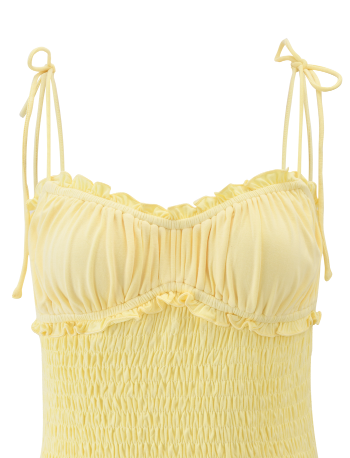 The SAFIRA TOP - LEMON by TIGERMIST is a light yellow, sleeveless jersey top featuring tie-up shoulder straps, a ruched bodycon fit, and gathered detailing on the bust and top.